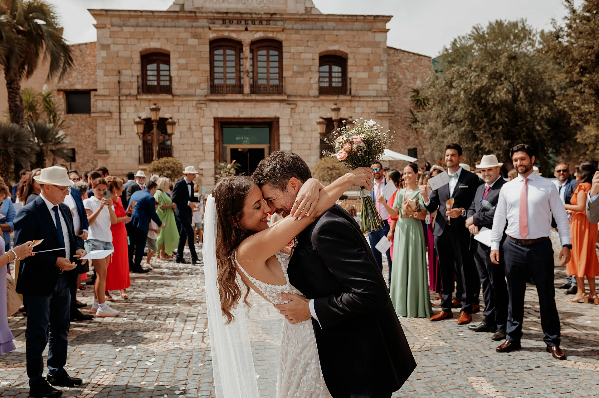 Novios abrazados durante la ceremonia civil frente a la bodega centenaria